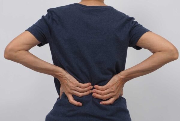 A person holding with lower back discomfort